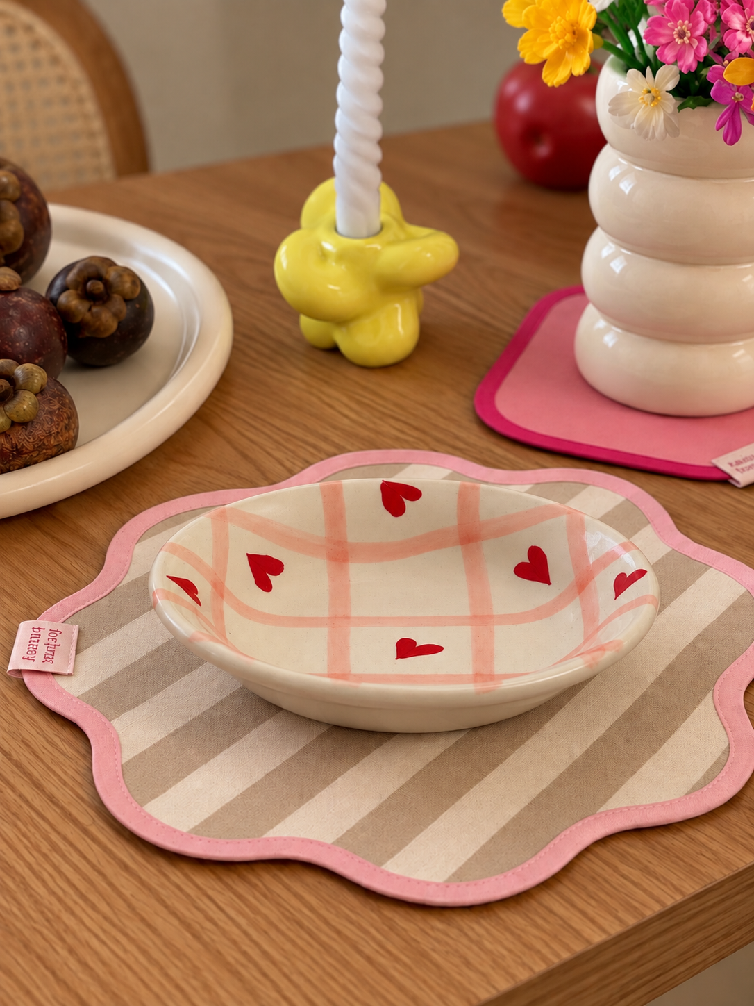 A ceramic bowl with a pink plaid pattern and red hearts.