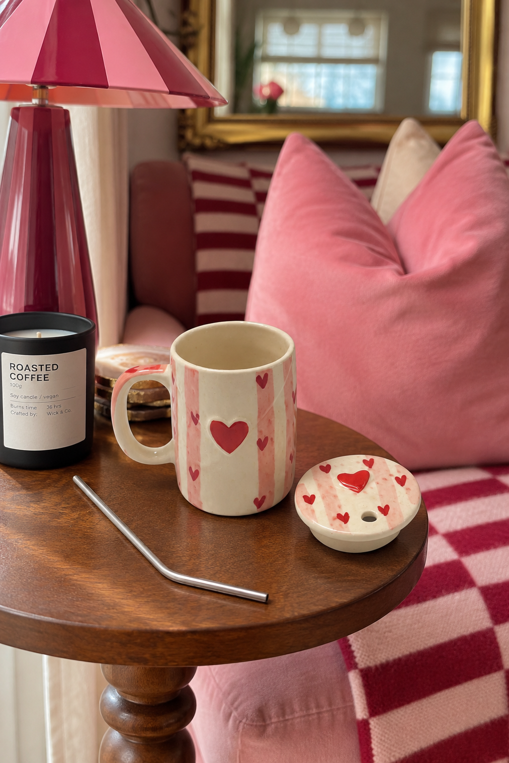 A white ceramic sipper with red hearts with matching lid