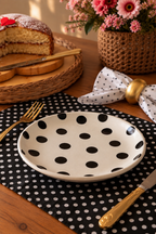 A white ceramic plate with black polka dots 