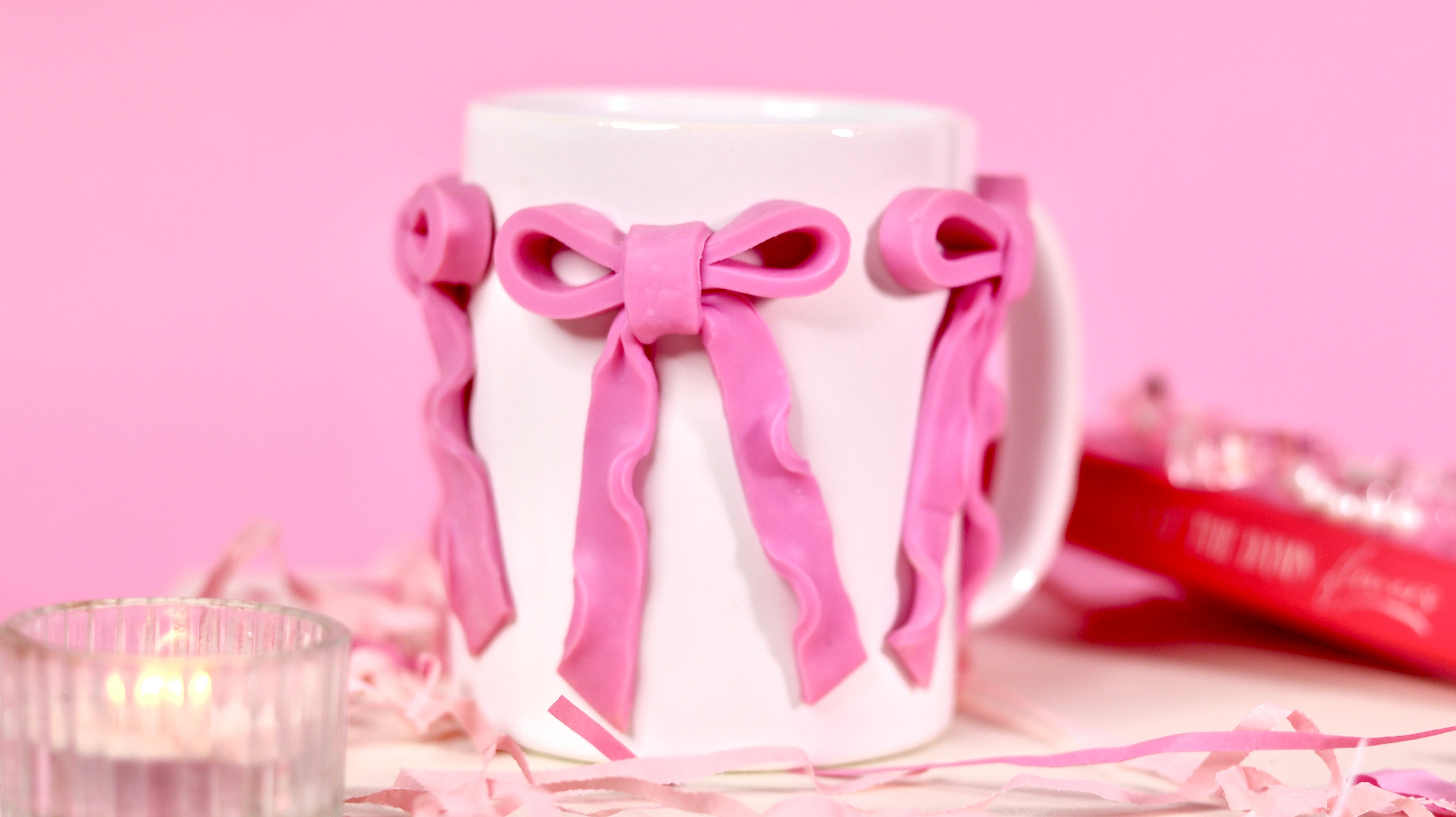 White mug with pink bows on a pink background