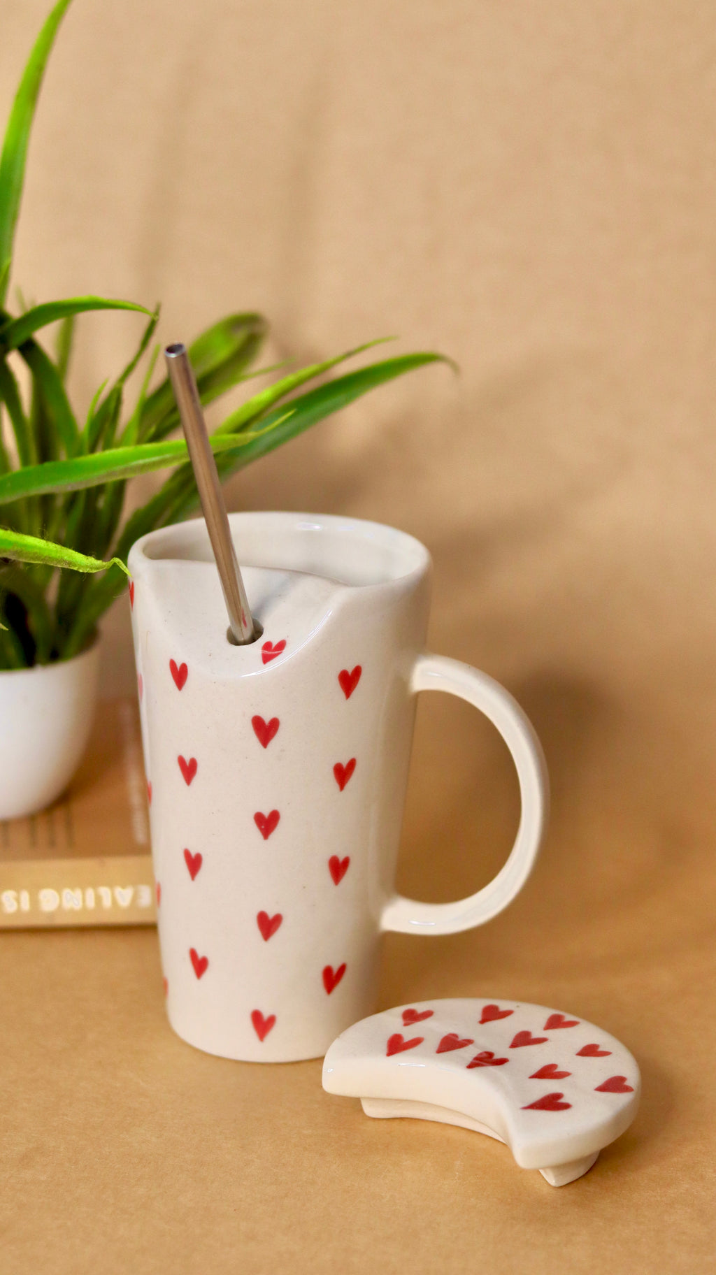 White ceramic sipper with red heart and straw