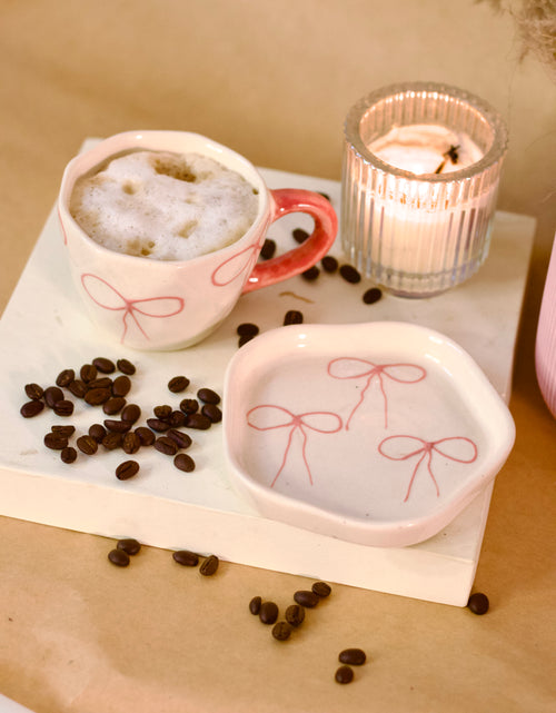 À La Bow ceramic cup and saucer set with delicate bow detail and soft blush finish by KLAEORA