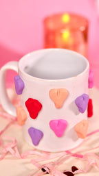 white ceramic mug with 3d colourful heart.
